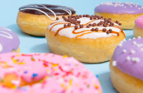 graphicstock image of a lot of colorful sweeties donuts over blue table background S Wc2utYTe