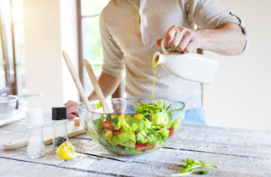 graphicstock unrecognizable young man in the kitchen preparing green salad rCxGrMiT