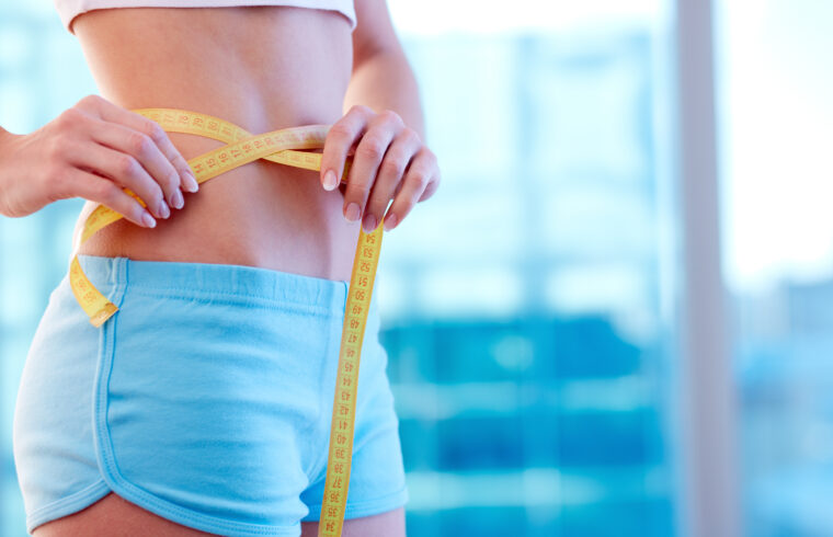 graphicstock close up of a woman in sportswear measuring her waist HgxLapx lb 1