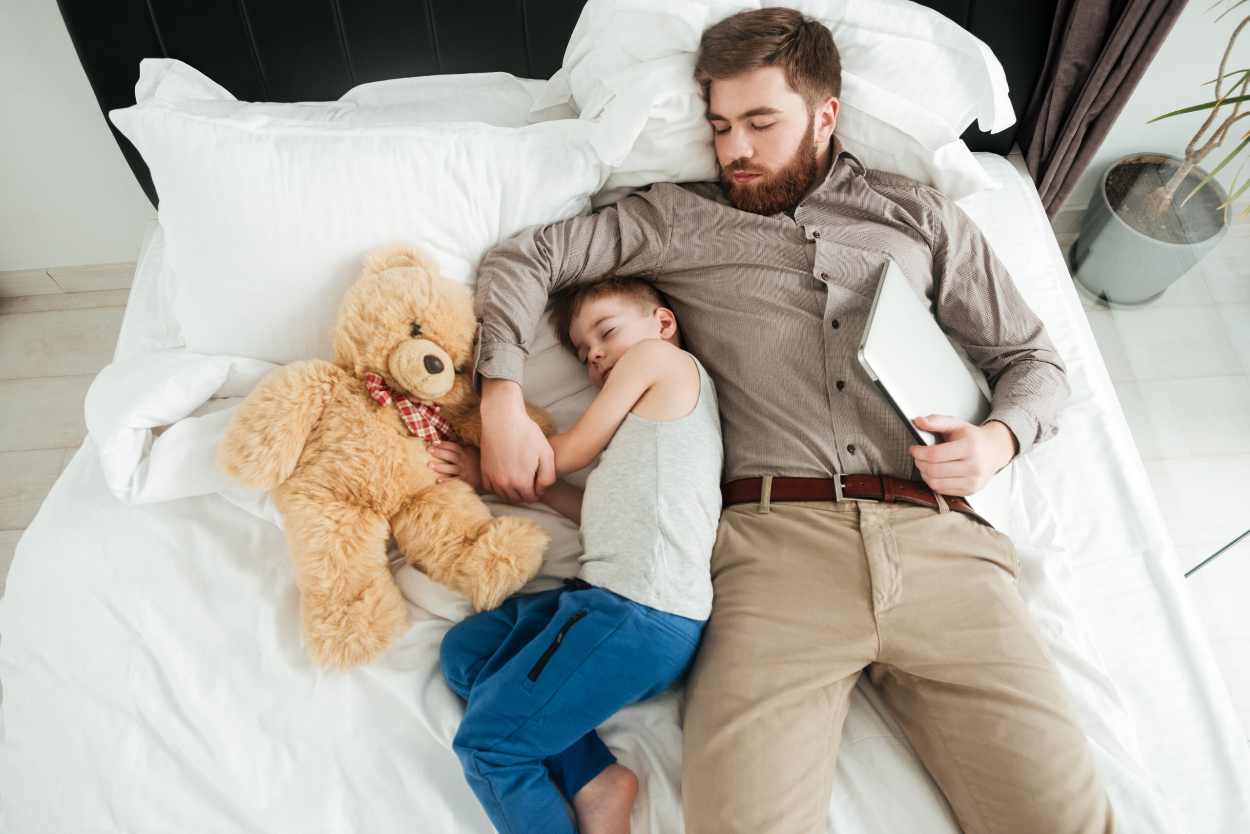 Ditch the Fad Diets: 5 Proven Strategies for Long-Term Weight Management 4 graphicstock image of cute little boy sleeping at home in bed with his bearded father and toy BuqLkoUhx scaled